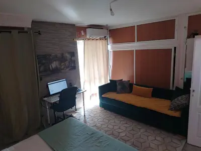 a living room with a couch and a desk with a computer at Appartement au centre rabat dyour jamaa in Rabat