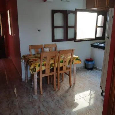 a dining room with a table and chairs and a window at Appartement Design Prés du Stade My Abdellah in Temara