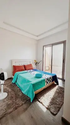 a bedroom with a bed and a large window at Superbe 1 chambre avec piscine et jardin, détente garantie, Wi-Fi, balcon et parking in Aïn Harrouda