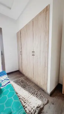 a bedroom with a bed with a wooden wall at Superbe 1 chambre avec piscine et jardin, détente garantie, Wi-Fi, balcon et parking in Aïn Harrouda
