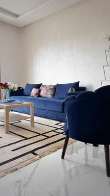 a living room with a blue couch and a table at Superbe 1 chambre avec piscine et jardin, détente garantie, Wi-Fi, balcon et parking in Aïn Harrouda