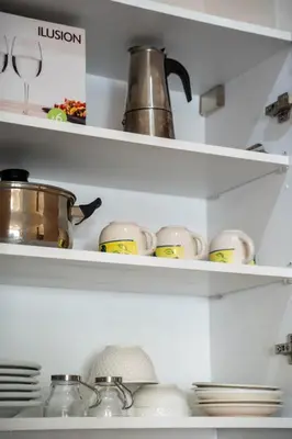 a shelf with cups and dishes in a kitchen at Superbe 1 chambre avec piscine et jardin, détente garantie, Wi-Fi, balcon et parking in Aïn Harrouda