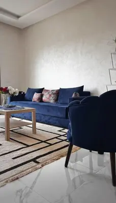 a living room with a blue couch and a table at Superbe 1 chambre avec piscine et jardin, détente garantie, Wi-Fi, balcon et parking in Aïn Harrouda