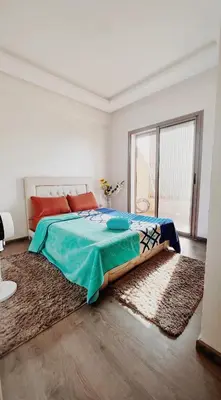 a bedroom with a bed and a large window at Superbe 1 chambre avec piscine et jardin, détente garantie, Wi-Fi, balcon et parking in Aïn Harrouda