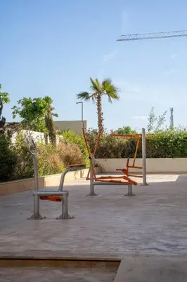 a playground with a slide and a swing at Superbe 1 chambre avec piscine et jardin, détente garantie, Wi-Fi, balcon et parking in Aïn Harrouda