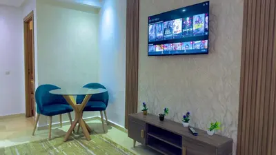 a room with a table and two chairs and a television on a wall at Super appart vue sur mer in Rabat