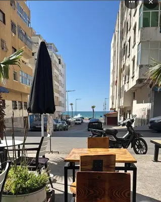 a table and chairs and an umbrella on a street at Super appart vue sur mer in Rabat