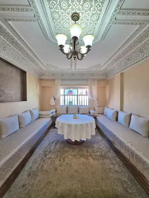 a living room with a table and a chandelier at Appartement Rabat in Rabat