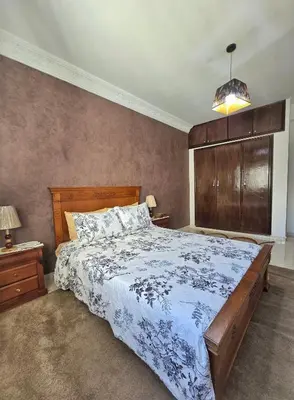 a bedroom with a large bed with a wooden headboard at Appartement Rabat in Rabat