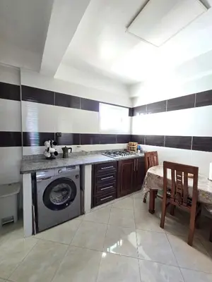 a kitchen with a washing machine and a table with chairs at Appartement Rabat in Rabat