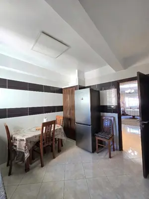 a kitchen with a table and chairs and a refrigerator at Appartement Rabat in Rabat