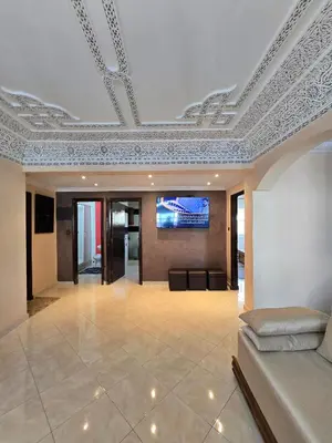 a living room with a couch and a tv on a ceiling at Appartement Rabat in Rabat