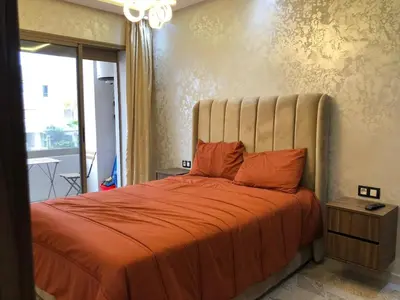 a bedroom with a large bed with an orange blanket at Luxury Studio with Pool and Relaxing Atmosphere in O Ben Slimane