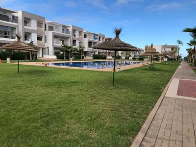 a resort yard with umbrellas and a swimming pool at Luxury Studio with Pool and Relaxing Atmosphere in O Ben Slimane