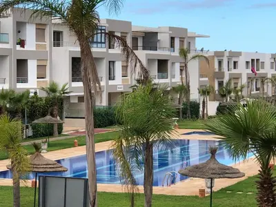 a view of a resort with palm trees and a swimming pool at Luxury Studio with Pool and Relaxing Atmosphere in O Ben Slimane