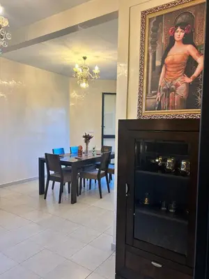 a dining room with a table and a painting of a woman at Régina AppartHotel in Casablanca