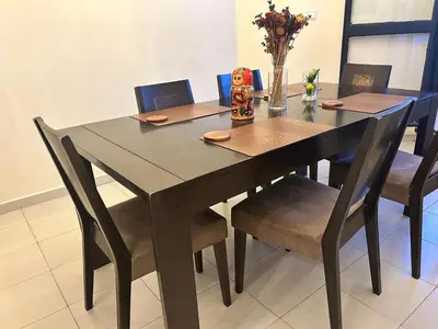 a dining room table and chairs with a table and a vase of flowers at Régina AppartHotel in Casablanca