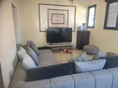 a living room with a couch and a flat screen tv at Régina AppartHotel in Casablanca