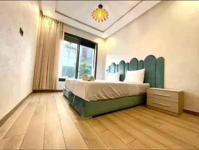 a bedroom with a large bed with a green headboard at Marco in Casablanca