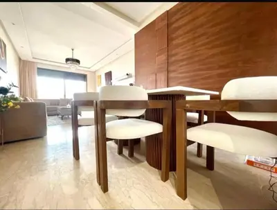 a dining room with a table and white chairs at Marco in Casablanca