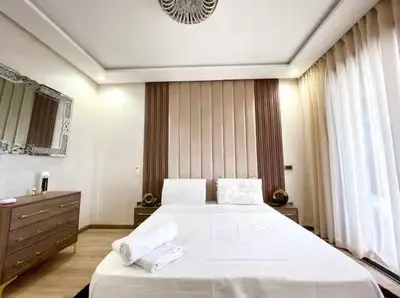 a bedroom with a large white bed and a dresser at Marco in Casablanca