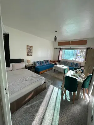 a bedroom with a bed and a living room at Cozy Studio in Diour Jammae in Rabat