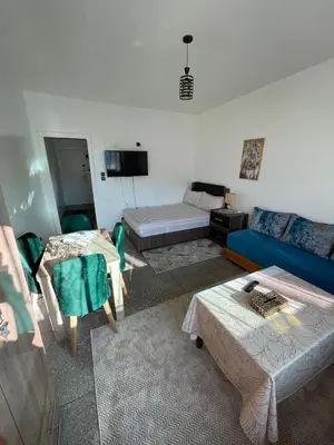 a living room with a blue couch and a bed at Cozy Studio in Diour Jammae in Rabat