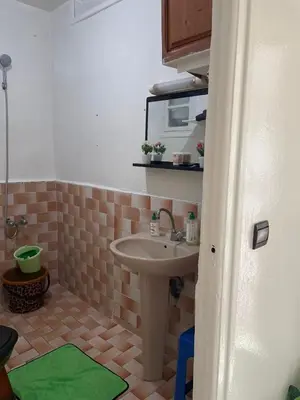 a small bathroom with a sink and a green rug at Cozy Studio in Diour Jammae in Rabat