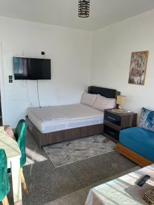 a room with a bed and a couch and a tv at Cozy Studio in Diour Jammae in Rabat