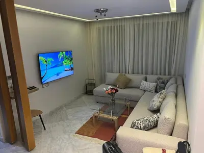 a living room with a couch and a tv at Les terrace d'anfa in Casablanca