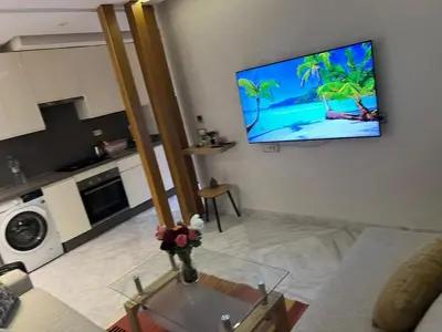 a living room with a flat screen tv on the wall at Les terrace d'anfa in Casablanca
