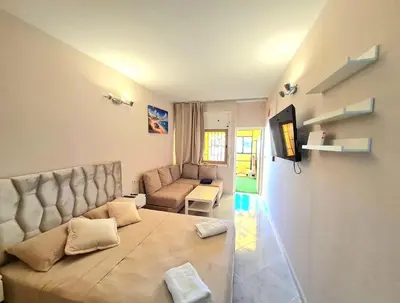 a living room with a couch and a television at Newly Apartment refurbished central calm charming in Rabat