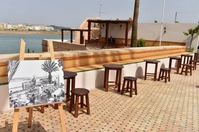 a row of tables and stools in front of a bar at Newly Apartment refurbished central calm charming in Rabat