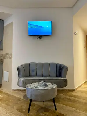 a living room with a couch and a tv on a wall at Social apartment in Rabat