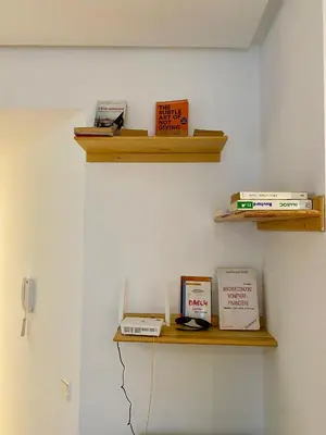a room with a shelf with books on it at Social apartment in Rabat