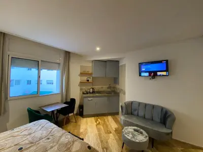 a bedroom with a bed and a couch and a kitchen at Social apartment in Rabat