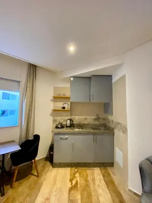 a kitchen with a sink and a desk in a room at Social apartment in Rabat