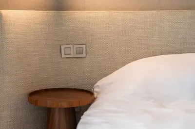 a bed with a wooden end table next to a bed at Luxury Apartment Anfaplace style & elegant in Casablanca