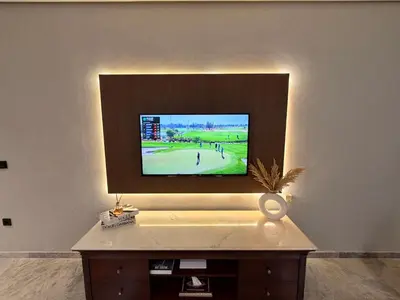 a flat screen tv on a wall with a table at MetroSuite in Casablanca