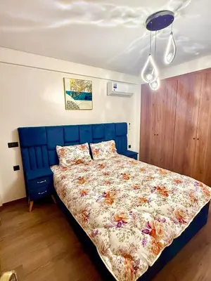 a bedroom with a bed with a blue head board at Modern studio in Burgundy in Casablanca-Port