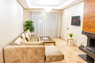 a living room with a couch and a fireplace at Dar Bouazza Luxury apartment with pools garden sports courts parking near the sea in Dar Bouazza