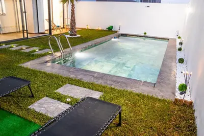 a swimming pool in the middle of a yard at Dar Bouazza Luxury apartment with pools garden sports courts parking near the sea in Dar Bouazza