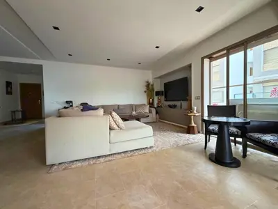 a living room with a white couch and a table at Appartement Premium 3 Chambres Piscine et Accès Plage Mansouria in O Ben Slimane
