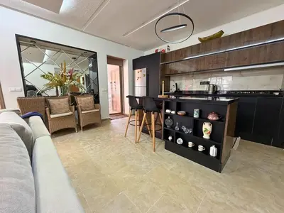 a living room with a couch and a kitchen at Appartement Premium 3 Chambres Piscine et Accès Plage Mansouria in O Ben Slimane