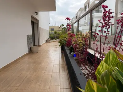 a corridor of a building with flowers and plants at Appartement Premium 3 Chambres Piscine et Accès Plage Mansouria in O Ben Slimane