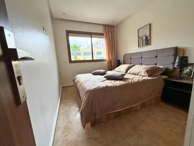 a bedroom with a large bed with a window at Appartement Premium 3 Chambres Piscine et Accès Plage Mansouria in O Ben Slimane
