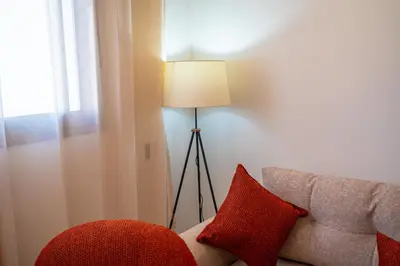 a lamp sitting next to a couch with a red pillow at KeyLiving 501 3 pers Emplacement Top Wifi in Casablanca