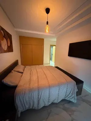 a bedroom with a large bed in a room at Superbe appartement 120 mc, Plage à pieds, 3 piscines & calme garanti - Sidi Rahal Plage in Sidi Rahal