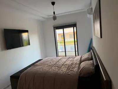 a bedroom with a bed and a window at Superbe appartement 120 mc, Plage à pieds, 3 piscines & calme garanti - Sidi Rahal Plage in Sidi Rahal