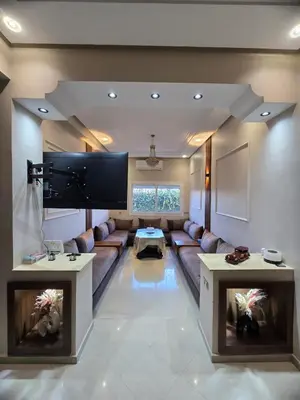 a large living room with a couch and a tv at Bel appartement in O Ben Slimane